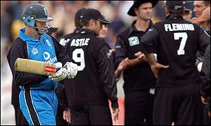 England skipper Nasser Hussain walks past a jubilant New Zealand side after being caught by Stephen Fleming