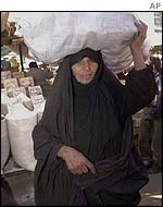 Iraqi woman carries market produce