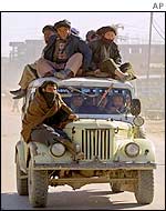 Afghans pile on to a Soviet-made jeep being used as a taxi in Mazar-e-Sharif
