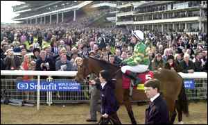 Charlie Swan on Istabraq and trainer Aidan O'Brien pass the packed stand on their way to post 