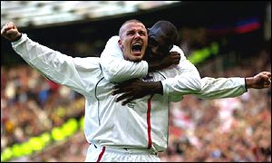 England captain David Beckham is hugged by team-mate Emile Heskey after scoring against Greece in the World Cup qualifier 