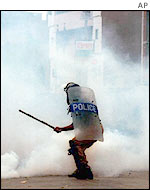 Dhaka policeman faces smoke-bombs from rioters