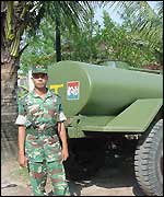 A soldier guards a water tanker