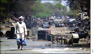 A Muslim man walks past destroyed houses near Ahmedabad