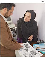 Editor of Afghan women's magazine discusses page layout with colleague