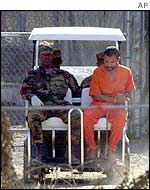 A golf cart is used to move a prisoner in Camp X-Ray