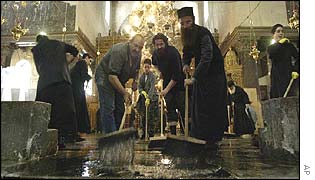 Priest and volunteers clean the Church of the Nativity
