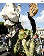 A protester in Berlin dressed as the earth pretends to be strangled by an effigy of George W Bush