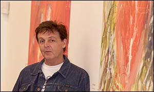 McCartney beside his paintings