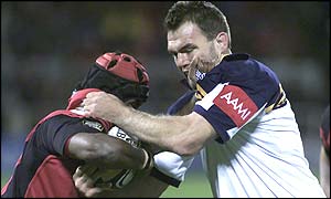 Crusaders' Marika Vunibaka is tackled by the Brumbies' Owen Finegan