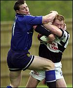 Brett Davey tussles with Steve Hanley for possession