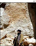 Taleban fighter stands at site of demolished Buddha