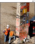 Surveyors examine the base of the last standing steel beam from the collapsed south tower of the World Trade Center