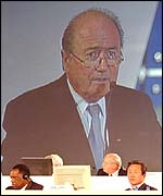 Sepp Blatter looms on a giant screen over Issa Hayatou
