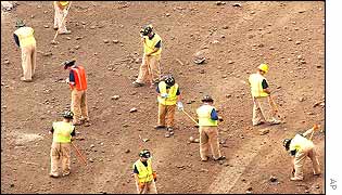 Recovery workers rake the ground at the WTC site