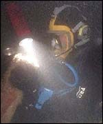 Divers examine a sunken tank