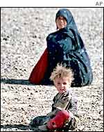 Mother and child waiting in a barren camp near the Iranian border