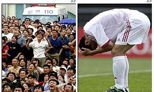 Crowds in Beijing groan in disappointment as a Chinese player on the pitch holds his head in agony
