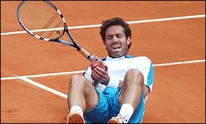 Corretja grabs his right hand after a heavy fall