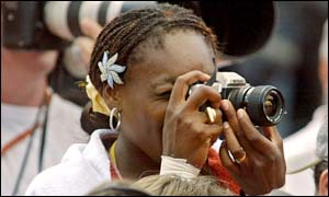 Venus Williams tries to take a photo of sister Serena lifting the French Open
