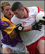 Tyrone's Sean Cavanagh forces his way past Wexford's Niall Murphy