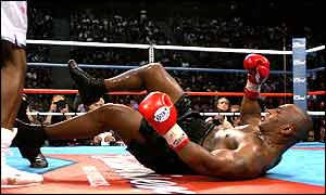 Mike Tyson sprawls on the canvas in the fourth bur Lewis was docked a point for a push