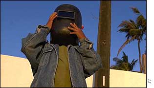 A child views the eclipse through a welding mask