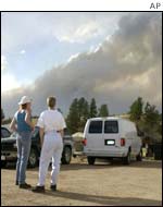 As a plume of smoke rises from in the mountains north of Florissant, Colorado