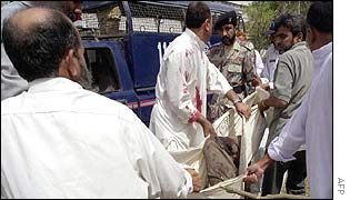 Rescue workers rush an injured person into a waiting emergency vehicle
