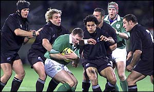 Ireland's John Kelly feels the force of the New Zealand defence