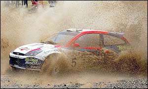 Great Britain's Colin McRae and Nicky Girst drive through the muddy waters of the Elatia special stage