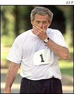 US President George W Bush wipes his face after a run