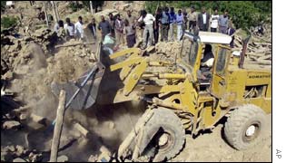 A bulldozer is brought in to move wreckage