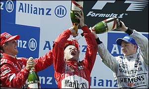 Michael Schumacher and Kimi Raikkonen drench Barrichello with champagne 