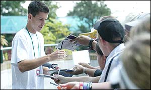 British number one and fourth seed Tim Henman signs autographs for waiting supporters on his way into Wimbledon