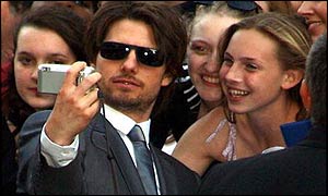 Tom Cruise takes a photo of himself with a fan