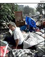 A woman sits amid her belongings after her home where she lived for 50 years was torn down