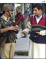 Soldier questions Kashmiri Muslim at checkpoint in Srinagar