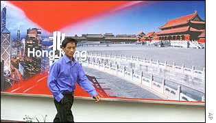 A Chinese man walks past an advertisement highlighting the close relationship between Hong Kong and China