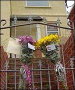 Flowers pinned to the gate of 9 Kelvin Road, Clydach