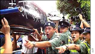 Hong Kong police give directions to human rights protesters carrying a coffin symbolising the death of democracy