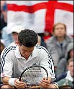 Henman with flags and fans in background
