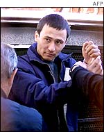 An unidentified recaptured detainee from the Woomera detention centre is lead by police to the Port Augusta Magistrate court, 01 July 2002, after they were rounded up in a huge police hunt