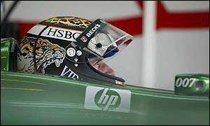 Eddie Irvine watches the action as he waits to go out for another run in the Jaguar