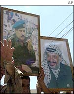 Palestinian protesters hold pictures of Yasser Arafat and the ousted Jibril Rajoub