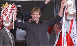 Arsenal captain Tony Adams shows off the Premiership and FA Cup trophies