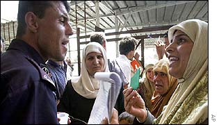 Woman argues with Palestinian policeman at Jericho bus terminal