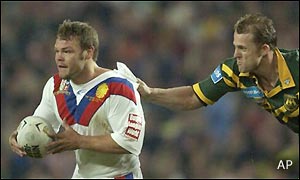 Keiron Cunningham of the Lions breaks the tackle of Scott Hill of the Kangaroos