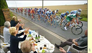 Cycling fans enjoy a picnic on the roadside as the riders rush by