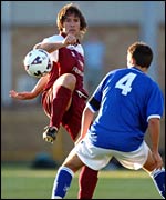 Barry's Ian Bishop tips the ball over Millwall's Charley Hearn